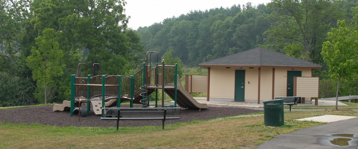 bathroom facilities, bench, garbage can, playground, path, trees