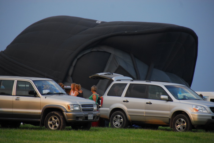 Darth Vader balloon, inflating, SUV, grass, people